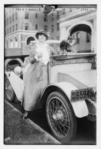 Photo of woman and child standing by an antique car