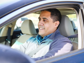 man smiling sitting in vehicle driver seat