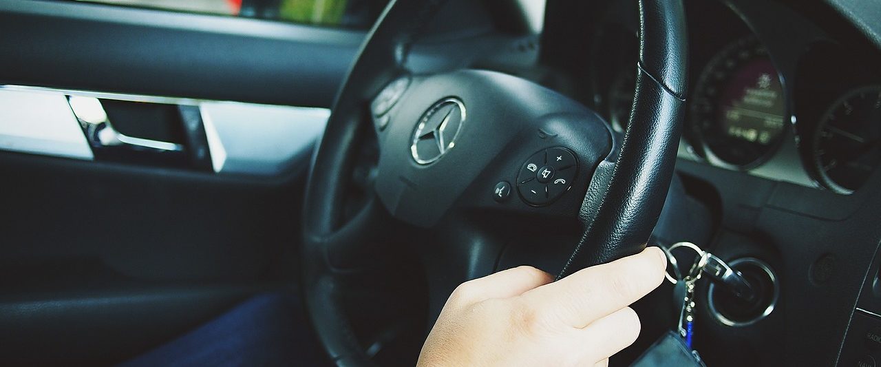 photo of hands holding a car steering wheel