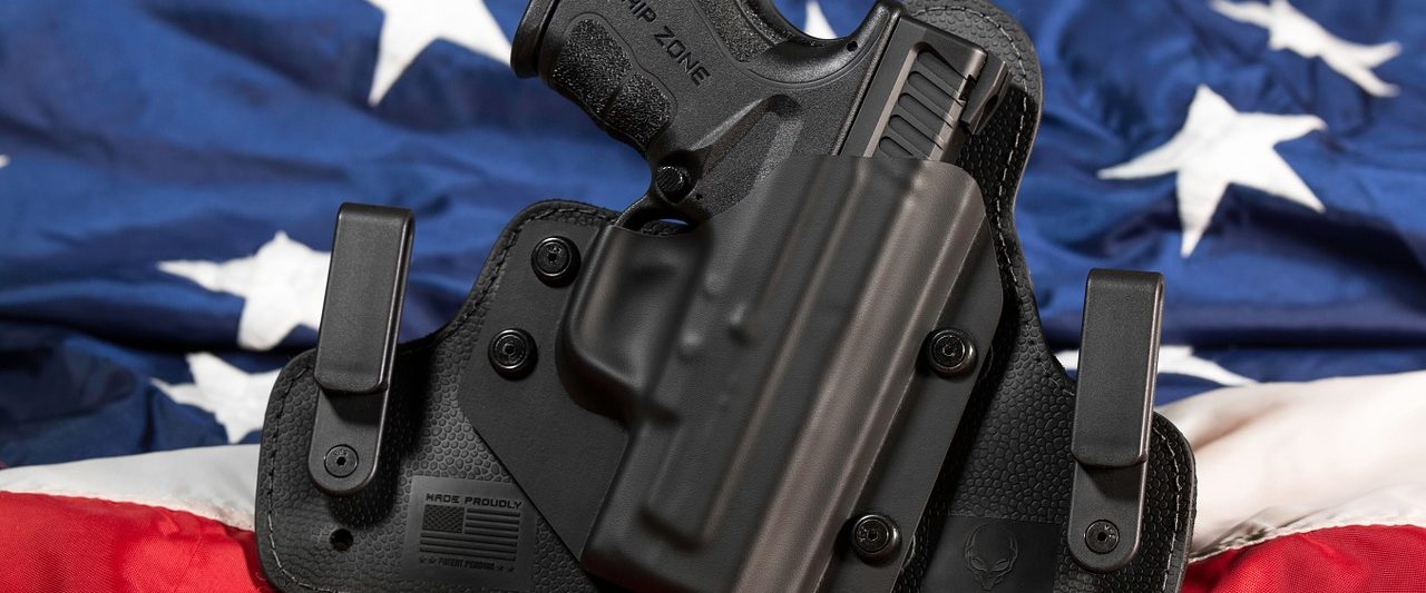 photo of gun in a holster in front of american flag