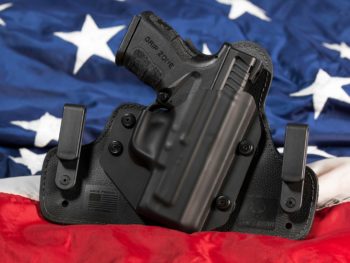 photo of gun in a holster in front of american flag