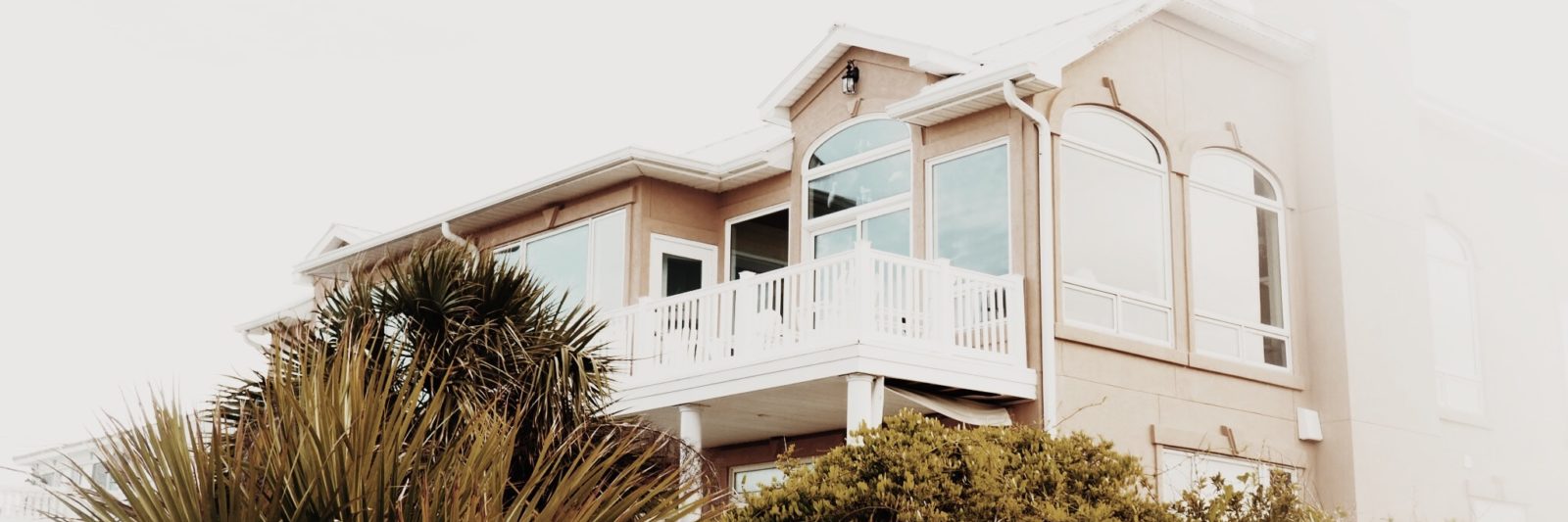 photo of a beach house on a hill covered in trees and sea oats