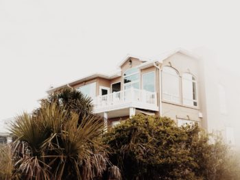 photo of a beach house on a hill covered in trees and sea oats